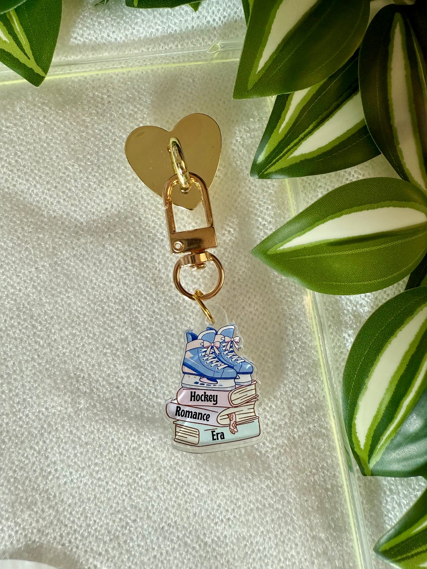 Keychain with book design on a light fabric background with leaves