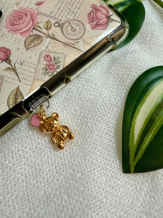 An e-reader charm of a gold teddy and a pink heart attached to a kindle 