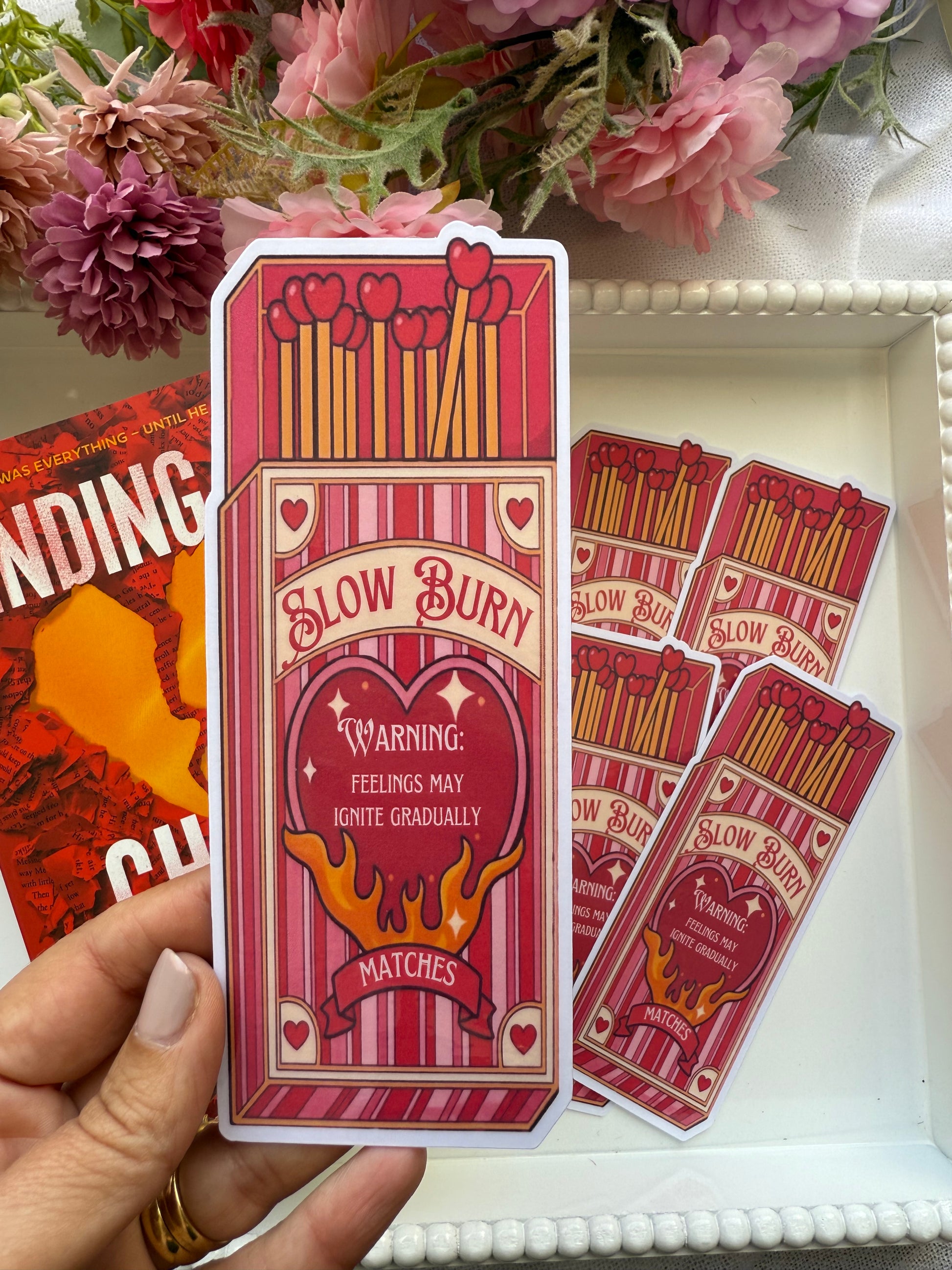 Set of matches with 'SLOW BURN' warning labels held by a hand.