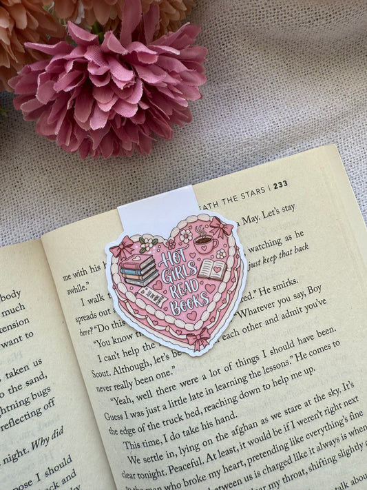 Heart-shaped coquette cake magnetic bookmark on an open book with pink flowers