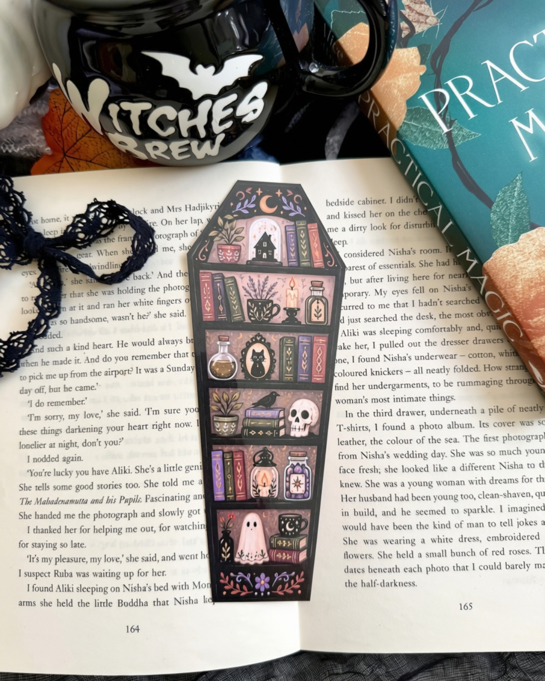 A coffin shaped bookmark featuring bookshelf filled with books and Halloween items. 