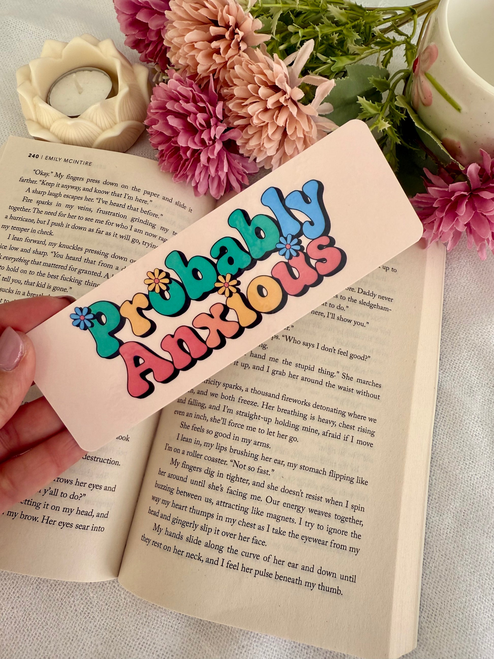 Colorful 'Probably Anxious' bookmark on an open book with flowers in the background