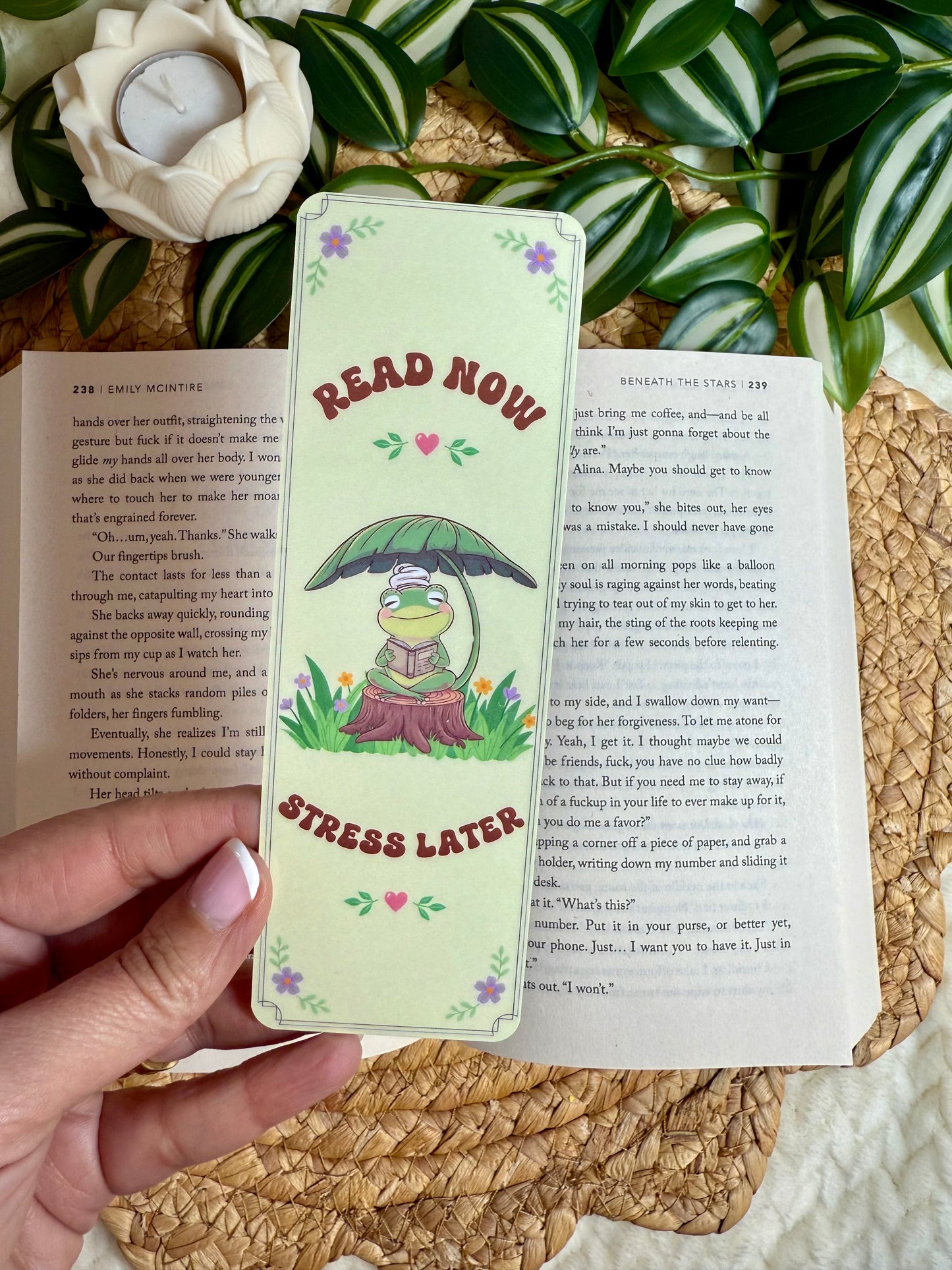 A bookmark of a reading frog saying read now stress later 