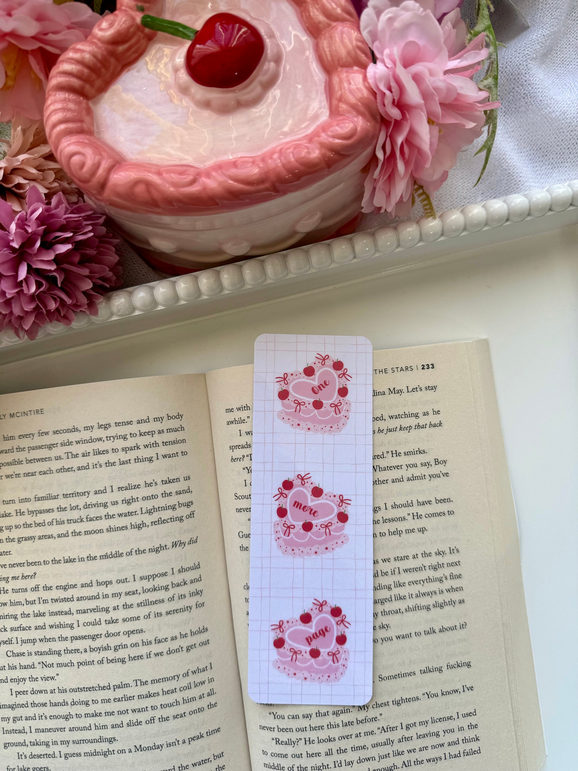 Coquette cake bookmark with the text One More Page