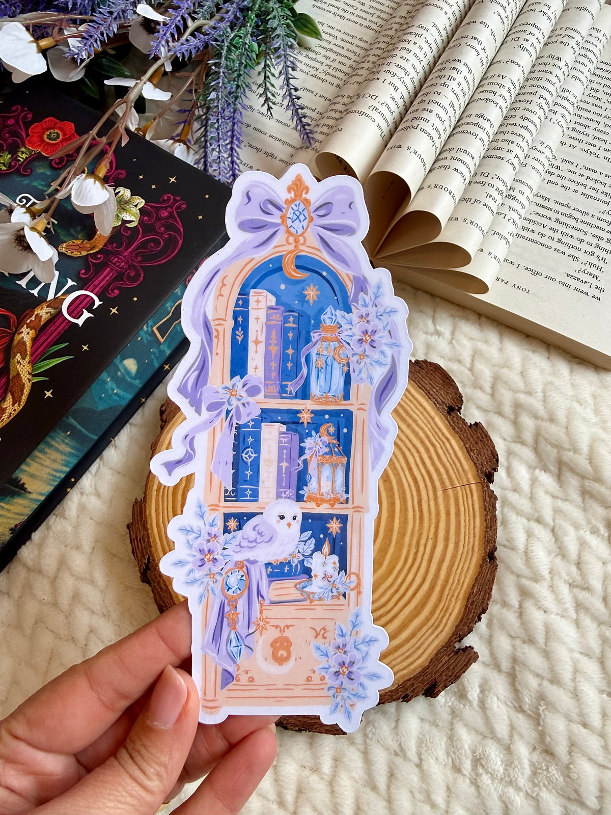 A die cut bookmark of an enchanted bookshelf with books and owl and stars. 