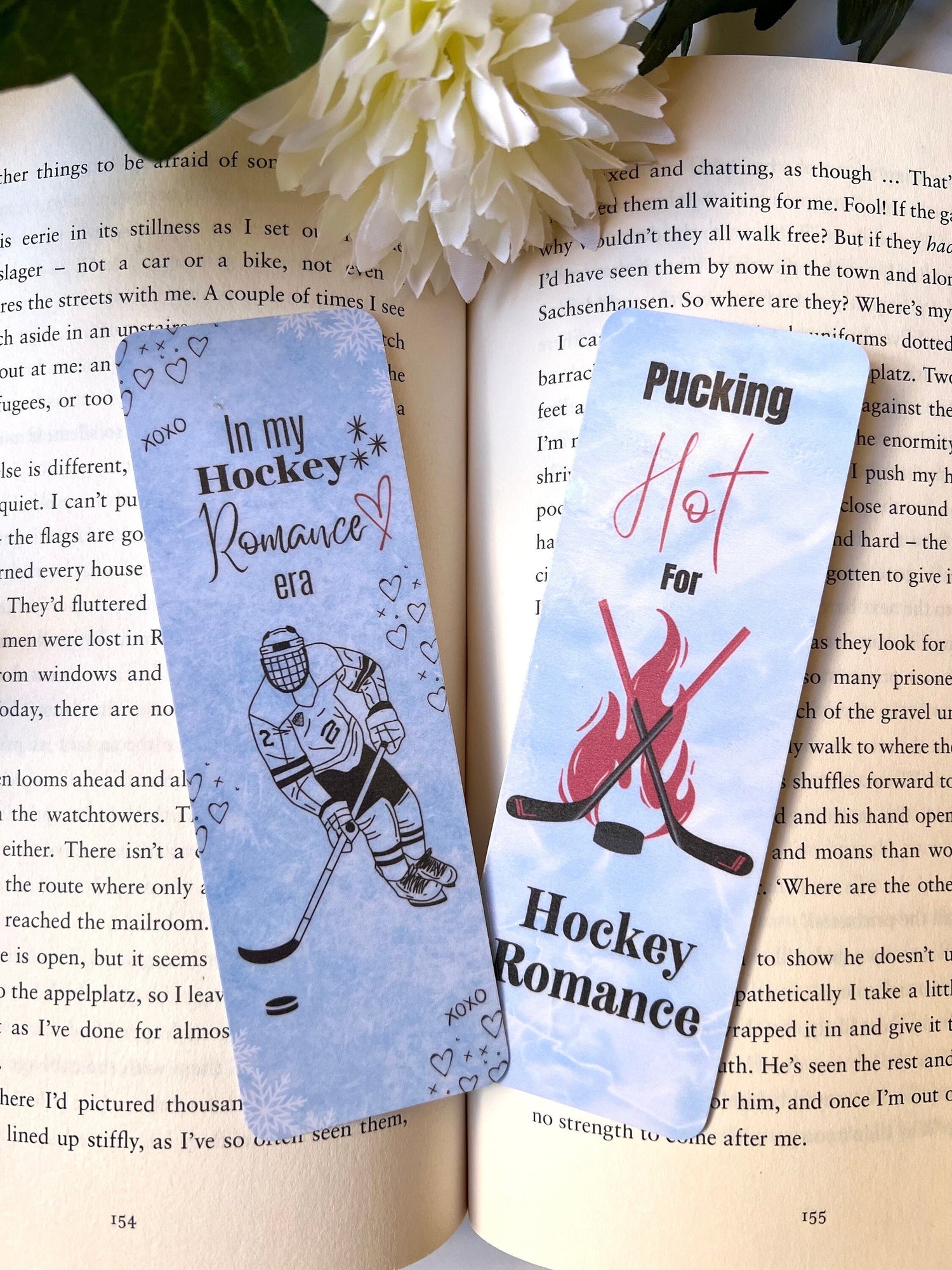 Two hockey romance themed bookmarks placed on an open book